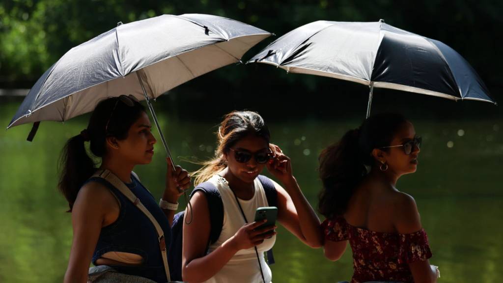 Regenschirme als Sonnenschutz: Grossbrittannien ächzt derzeit unter unüblich hohen Temperaturen.