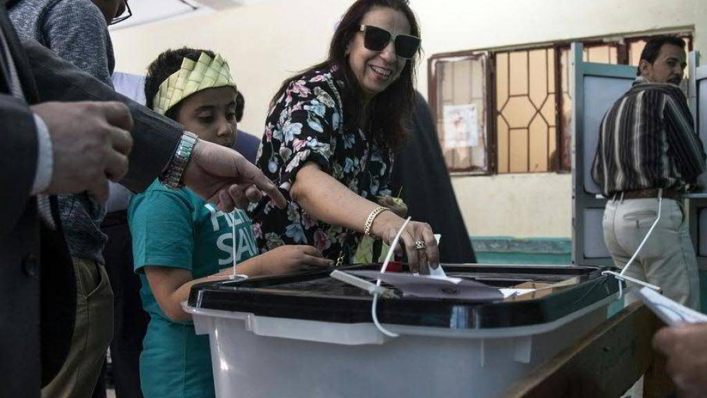Eine Frau wirft ihren Stimmzettel in die Urne eines Abstimmungslokals in Kairo - die Ägypter befinden in einem Referendum über mehr Machtbefugnisse für ihren Präsidenten.