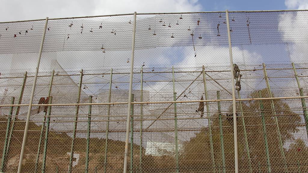 ARCHIV - Nach einem Migranten-Ansturm hängen Kleiderfetzen am Grenzzaun von Melilla. Foto: Europapress/dpa