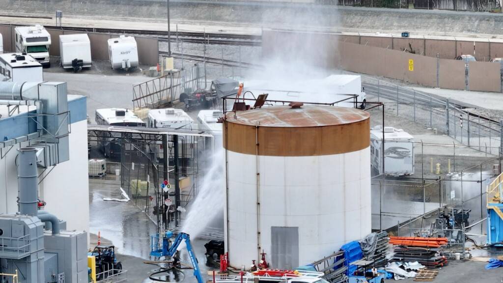 Wasser wird auf einen Tank gesprüht, der sich in einem Luft- und Raumfahrtwerk überhitzt hat. Die drohende Explosion eines Lagertanks mit einer brennbaren, gefährlichen Chemikalie hat in Südkalifornien zur Evakuierung eines großen Wohngebiets geführt. Foto: Jeff Gritchen/The Orange County Register/AP/dpa - ACHTUNG: Nur zur redaktionellen Verwendung und nur mit vollständiger Nennung des vorstehenden Credits