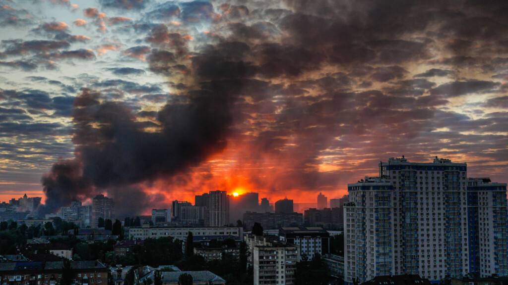 Nach einem massiven russischen Luftangriff steigt bei Sonnenaufgang Rauch über der Stadt auf. Foto: Zoya Shu/AP/dpa