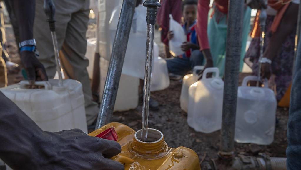 Menschen, die vor dem Konflikt in der äthiopischen Region Tigray geflohen sind, füllen im Flüchtlingslager Umm Rakouba in Qadarif im Ostsudan Plastikkanister mit Wasser.