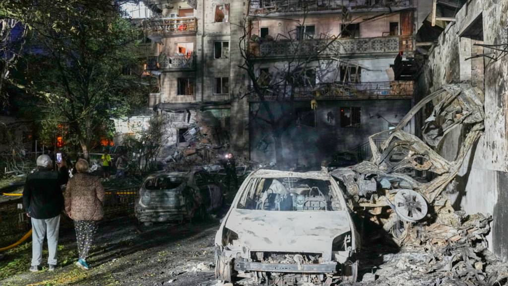 dpatopbilder - Anwohner gehen nach einem russischen Raketenangriff in Kiew, Ukraine, zwischen den Trümmern. Foto: Efrem Lukatsky/AP/dpa