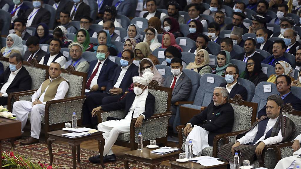 Aschraf Ghani (M), Präsident von Afghanistan, trägt eine FFP-Maske bei der Loja Dschirga, der großen Ratsversammlung. Ghani hatte die Loja Dschirga einberufen, um über das Schicksal von 400 inhaftierten Taliban zu entscheiden, denen teils schwerste Verbrechen vorgeworfen werden. Foto: Rahmat Gul/AP/dpa