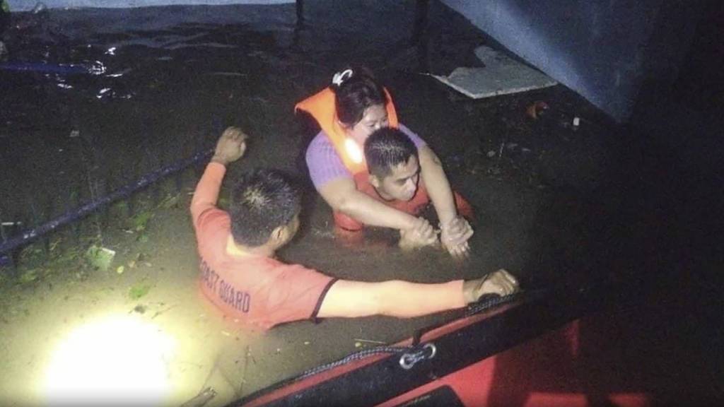 dpatopbilder - HANDOUT - Rettungskräfte bringen einen Einwohner in Sicherheit. Foto: Philippine Coast Guard/AP/dpa - ACHTUNG: Nur zur redaktionellen Verwendung im Zusammenhang mit der aktuellen Berichterstattung und nur mit vollständiger Nennung des vorstehenden Credits