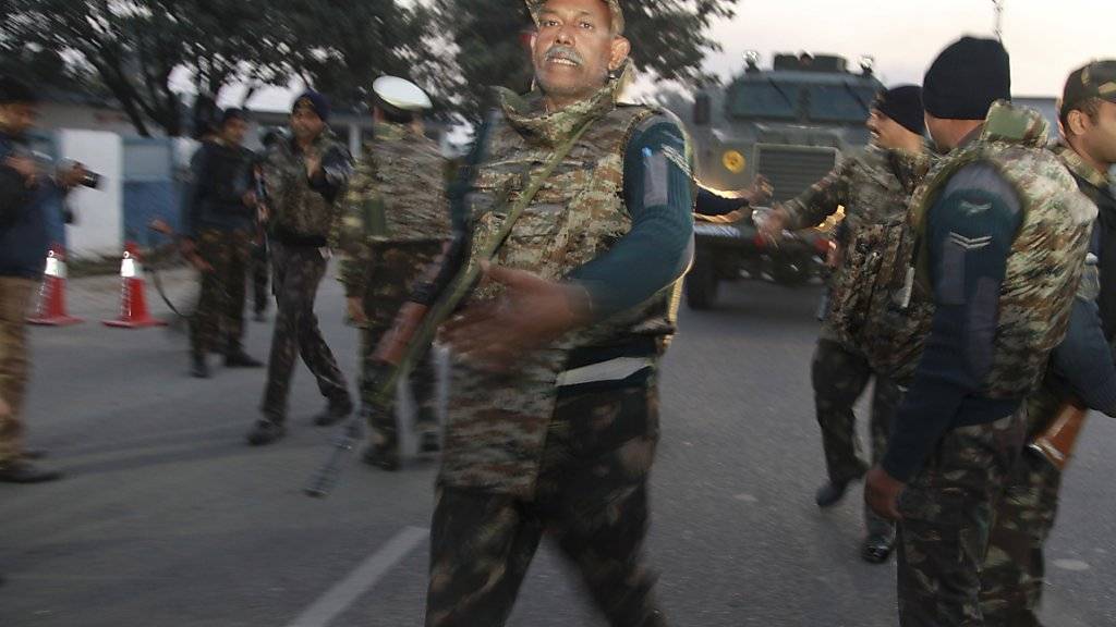 Indische Sicherheitskräfte patrouillieren vor der Luftwaffenbasis Pathankot, wo noch immer Schüsse fallen.