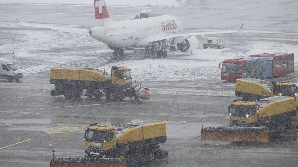Räumfahrzeuge befreien die Pisten und Rollwege auf dem Flughafen Zürich von Schneematsch. (Archivbild)