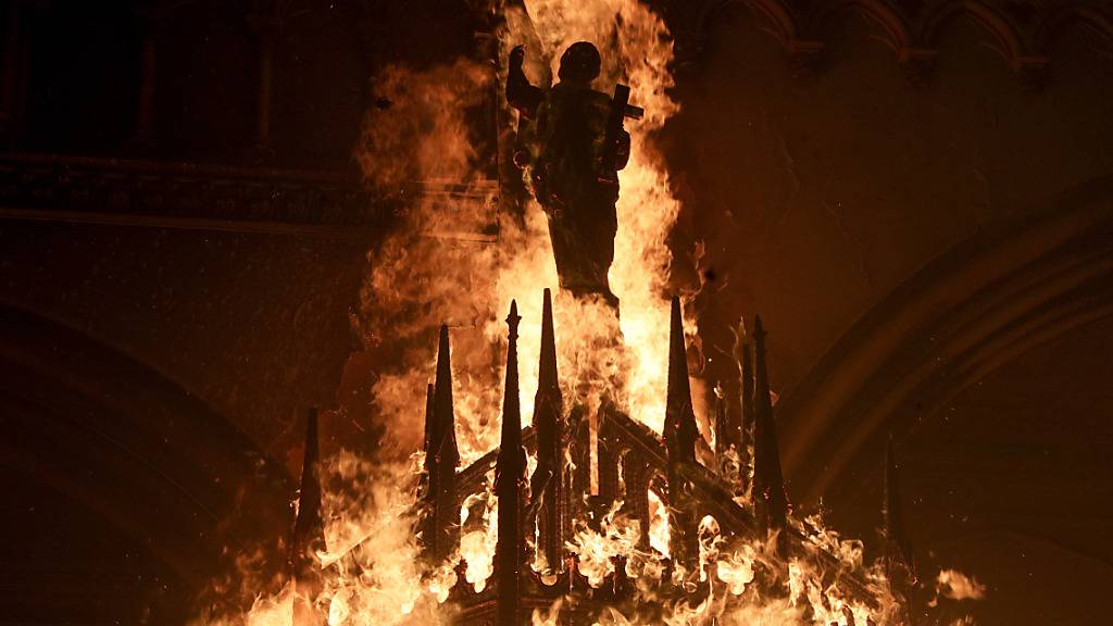 Eine Heiligenfigur in der brennenden Kirche San Francisco de Borja in Chiles Hauptstadt Santiago. Foto: Esteban Felix/AP/dpa