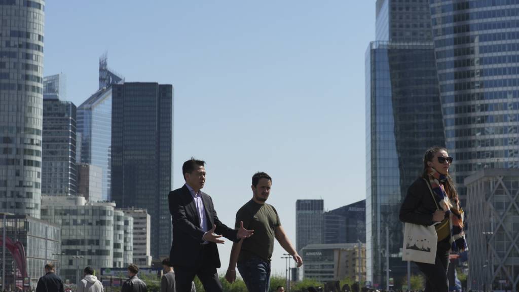 ARCHIV - Menschen schlendern durch das Geschäftsviertel La Defense außerhalb von Paris. Das hoch verschuldete Frankreich erhält nach monatelangem Ringen endlich einen Haushalt für das angelaufene Jahr. Foto: Thibault Camus/AP/dpa