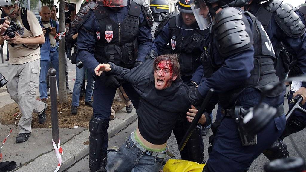 In Paris wird ein verwundeter Demonstrant von der Strasse weggebracht.