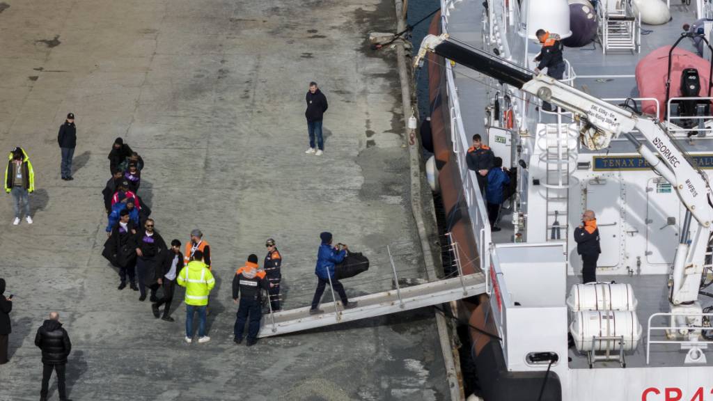 ARCHIV - Migranten besteigen im Hafen von Shengjin im Nordwesten Albaniens ein Schiff der italienischen Küstenwache.  Im Rechtsstreit um Italiens umstrittenes Asyl-Modell wirft ein Gutachten des Generalanwalts des Europäischen Gerichtshofs (EuGH) Zweifel auf, ob es in dieser Form bestehen kann. Foto: Vlasov Sulaj/AP/dpa