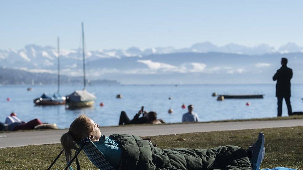 Eine Frau geniesst das frühlingshafte Wetter am Zürichsee. (KEYSTONE/Ennio Leanza)