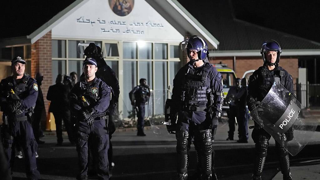 Einsatzkräfte der Polizei stehen Wache vor einer orthodoxen assyrischen Kirche. Der Angriff auf Geistliche einer christlichen Gemeinde in Sydney während eines Gottesdienstes ist von den Ermittlern als Terrorakt eingestuft worden. Foto: Mark Baker/AP/dpa