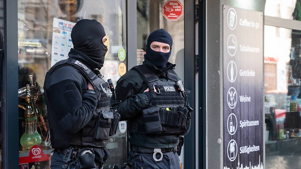 Polizisten stehen bei einer Razzia vor einem Spätkauf in Neukölln. Mit einer Großrazzia ist die Polizei am Donnerstag gegen Clankriminalität in Berlin und Umgebung vorgegangen. Foto: Christophe Gateau/dpa