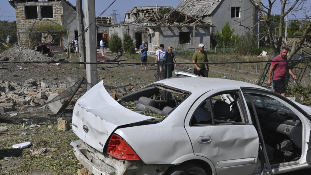 Menschen vor ihren beschädigten Häusern nach einem russischen Raketenangriff. Foto: Michael Shtekel/AP/dpa