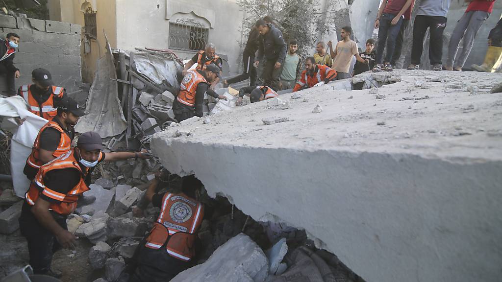 Palästinenser suchen  in einem Haus nach Überlebenden, das bei israelischen Luftangriffen zerstört wurde. Foto: Hatem Ali/AP/dpa