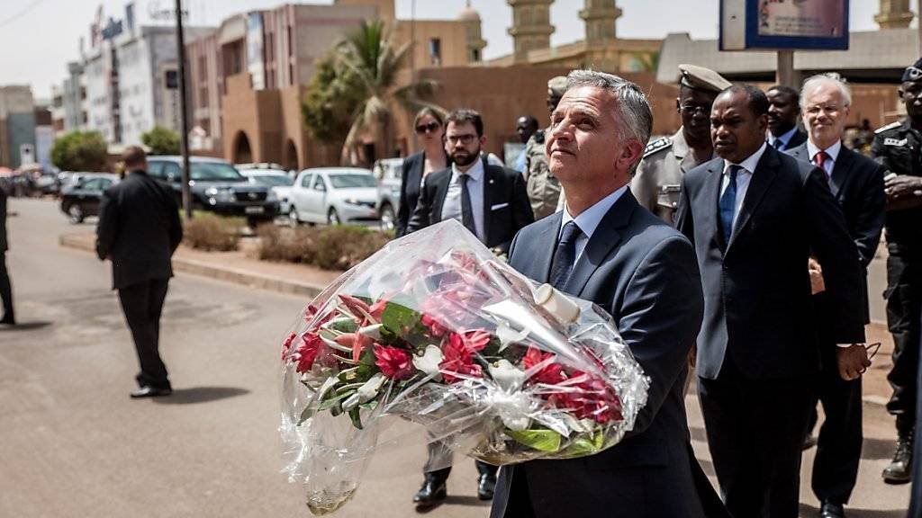 Zum Gedenken an die Opfer der Anschläge von Ouagadougou im Januar bringt Bundesrat Didier Burkhalter Blumen vor das Café, das damals angegriffen wurde.