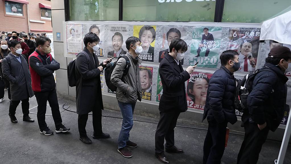 Menschen warten in einem Wahllokal in Seoul. Fünf Tage vor der Präsidentenwahl in Südkorea haben zahlreiche Menschen die Möglichkeit zur frühzeitigen Stimmabgabe genutzt. Die Beteiligung am ersten Vorwahltag habe den Rekordwert von 17,57 Prozent erreicht, berichteten südkoreanische Sender. Foto: Ahn Young-Joon/AP/dpa