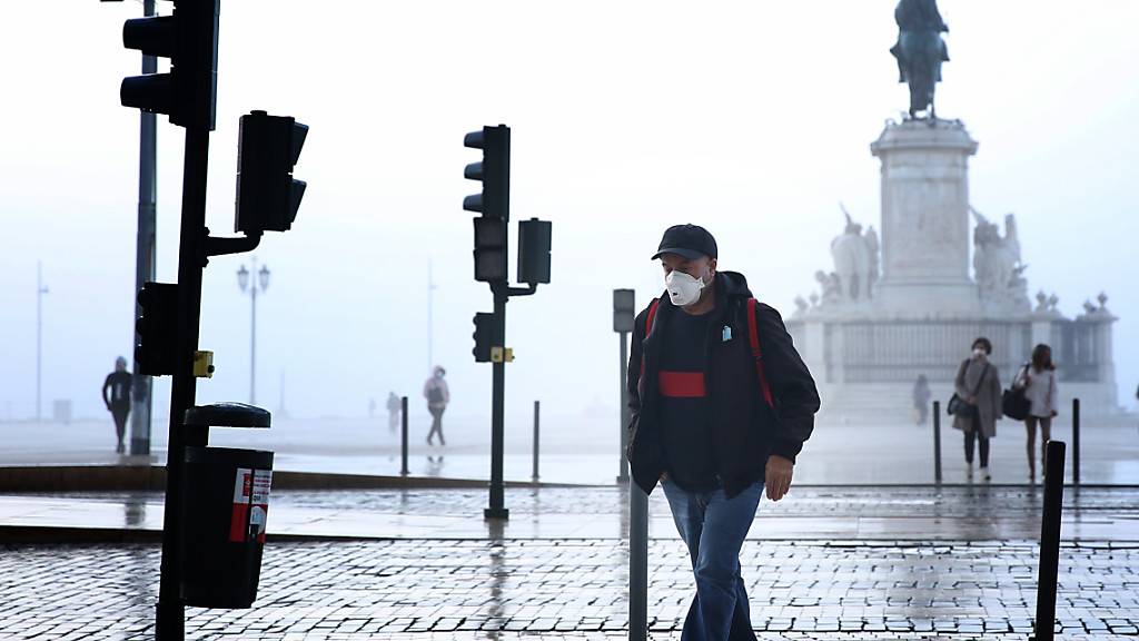 Ein Mann mit Mund-Nasen-Schutz geht durch Lissabon. Foto: Pedro Fiuza/ZUMA Wire/dpa