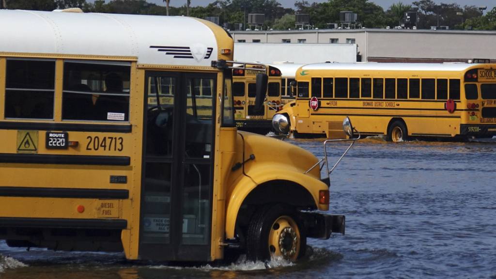 Ein Schulbus fährt durch das Hochwasser eines überschwemmten Parkplatzes, nachdem Tropensturm «Eta» mit starken Regenfällen über Florida zog. Foto: Joe Cavaretta/South Florida Sun-Sentinel/dpa