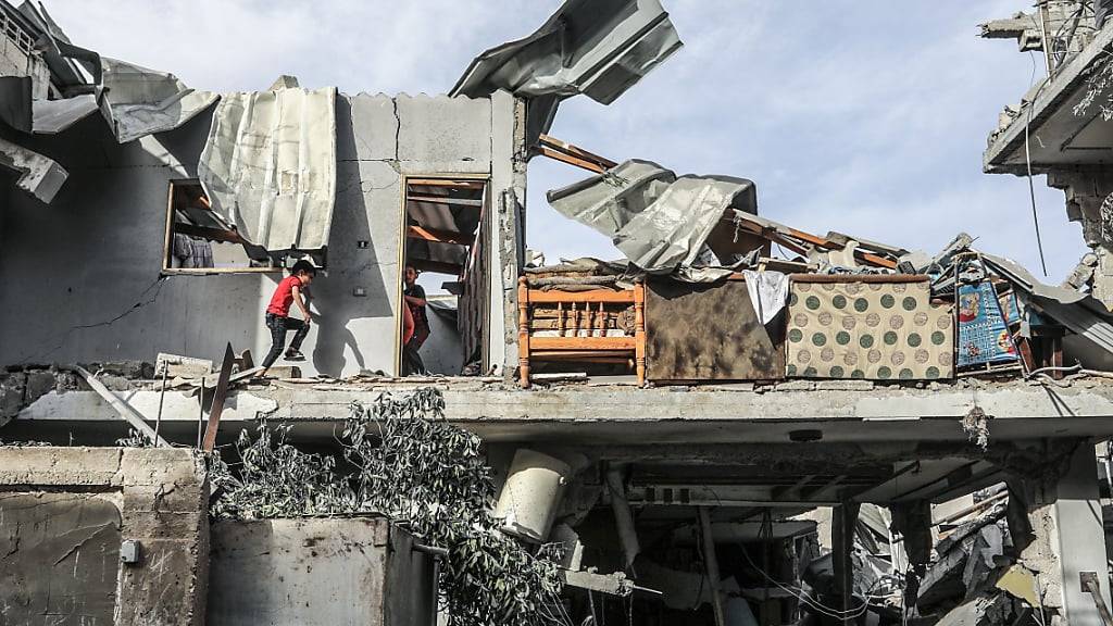 ARCHIV - Palästinenser inspizieren ein Haus, das nach einem israelischen Luftangriff zerstört wurde. Nach einem Angriff in Rafah erlag eine schwangere Frau ihren Verletzungen, ihr Baby konnte jedoch mit einem Kaiserschnitt gerettet werden - Nun ist es nach Angaben der örtlichen Gesundheitsbehörde gestorben. Foto: Abed Rahim Khatib/dpa