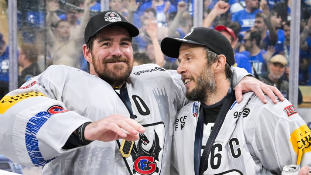 Meistergoalie Reto Berra (links) Arm in Arm mit Fribourgs Captain Julien Sprunger