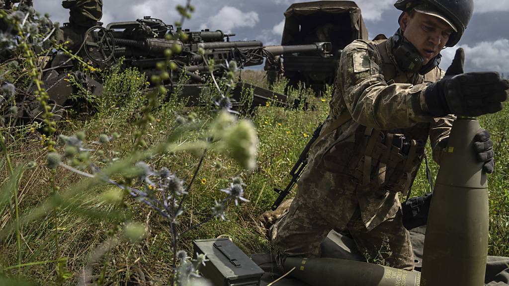 ARCHIV - Ein ukrainischer Soldat installiert einen Zünder für eine 155-mm-Artilleriegranate, bevor er mit einer von den USA gelieferten Haubitze des Typs M777 auf russische Stellungen schießt. Foto: Evgeniy Maloletka/AP/dpa