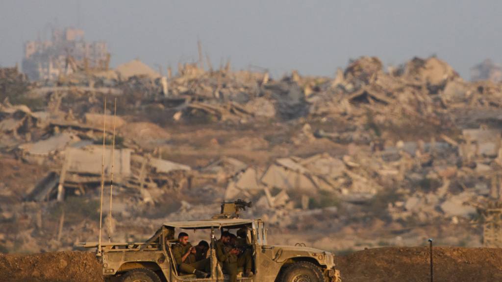 Israelische Soldaten ruhen sich in einem Fahrzeug auf einem Hügel über dem Gazastreifen im Süden Israels aus. Im Gazastreifen im Nahen Osten herrscht seit zwei Jahren Krieg. Am Montag wollen die Beteiligten über einen Friedensplan sprechen. Foto: Ariel Schalit/AP/dpa