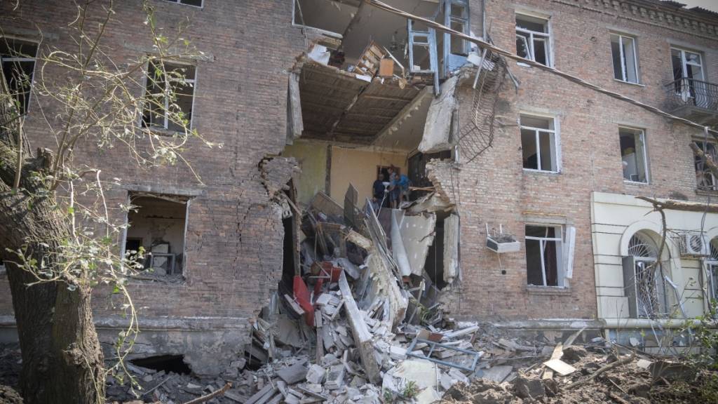 Menschen bergen einige ihrer Habseligkeiten aus einem Gebäude in Bachmut, das bei einem russischen Raketenangriff im Stadtzentrum beschädigt wurde. Foto: Efrem Lukatsky/AP/dpa