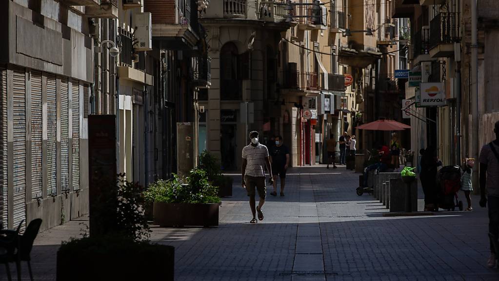 ARCHIV - Ein Mann mit Mundschutz geht durch die Innenstadt von Lleida. (zu dpa «Streit um Corona-Ausgehsperre in Katalonien spitzt sich zu») Foto: David Zorrakino/Europapress/dpa