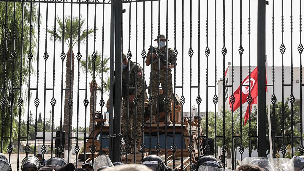 Soldaten der tunesischen Armee bewachen den Eingang des Parlamentsgebäudes während einer Demonstration einen Tag nachdem der tunesische Präsident Saied den Premierminister Hichem Mechichi abgesetzt hat. Die Arbeit des Parlaments ist zunächst für 30 Tage eingefroren. Foto: Khaled Nasraoui/dpa