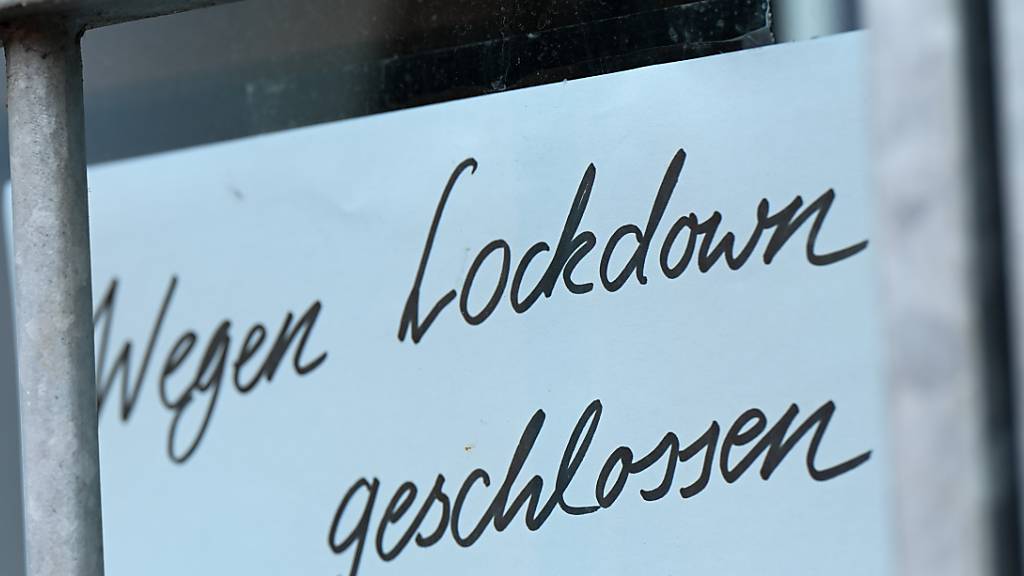 ARCHIV - Ein Zettel mit der Aufschrift «Wegen Corona geschlossen» hängt am Schaufenster eines Geschäfts. (zu dpa «Bund und Länder beraten über mögliche Fortsetzung von Corona-Lockdown») Foto: Arne Dedert/dpa