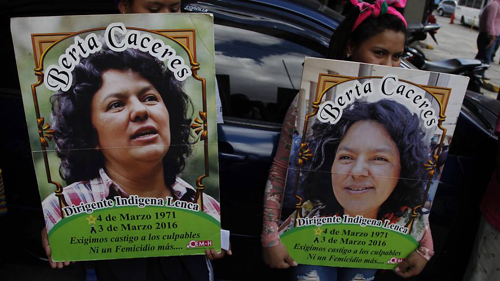 ARCHIV - Zwei Frauen halten bei einem Protest vor dem Sitz der Staatsanwaltschaft Plakaten mit dem Bild der honduranischen Umweltschützerin Berta Caceres. Foto: Fernando Antonio/AP/dpa