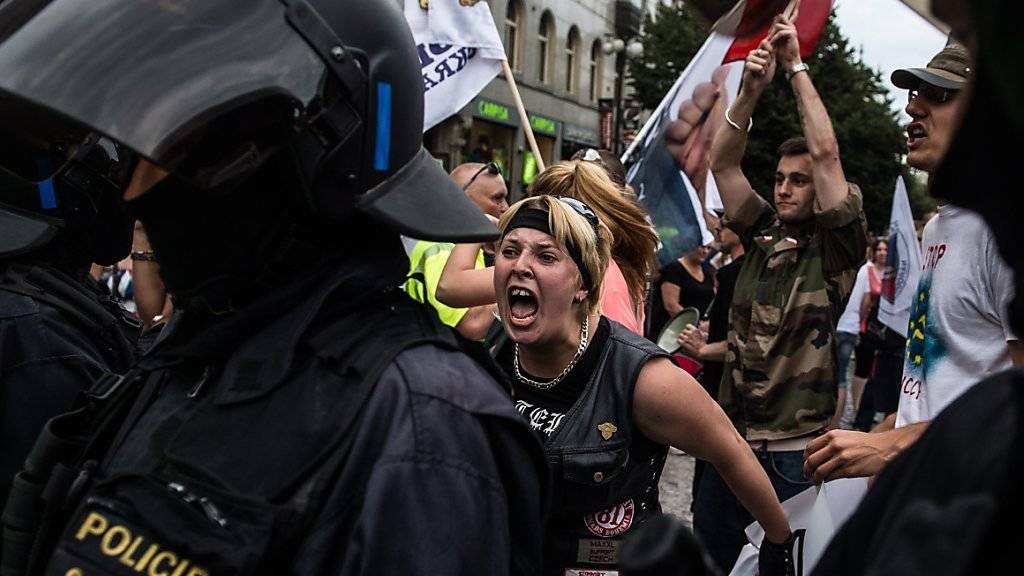 Demonstranten werden in Prag von der Polizei in Schach gehalten.