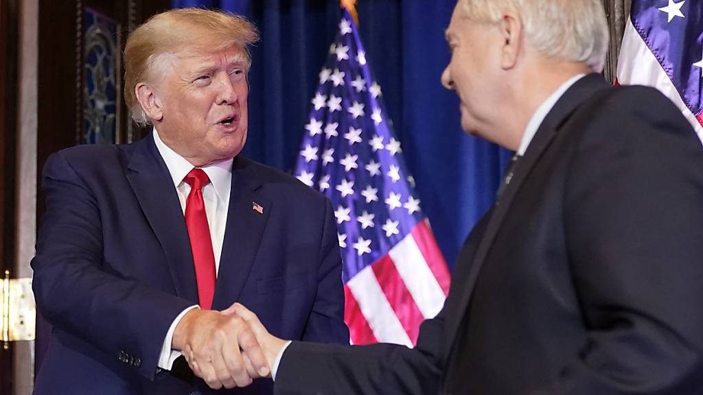 ARCHIV - Donald Trump, ehemaliger Präsident der USA, schüttelt Senator Lindsey Graham, Republikaner aus South Carolina, die Hand, als er bei einer Wahlkampfveranstaltung im South Carolina Statehouse spricht. Foto: Alex Brandon/AP/dpa