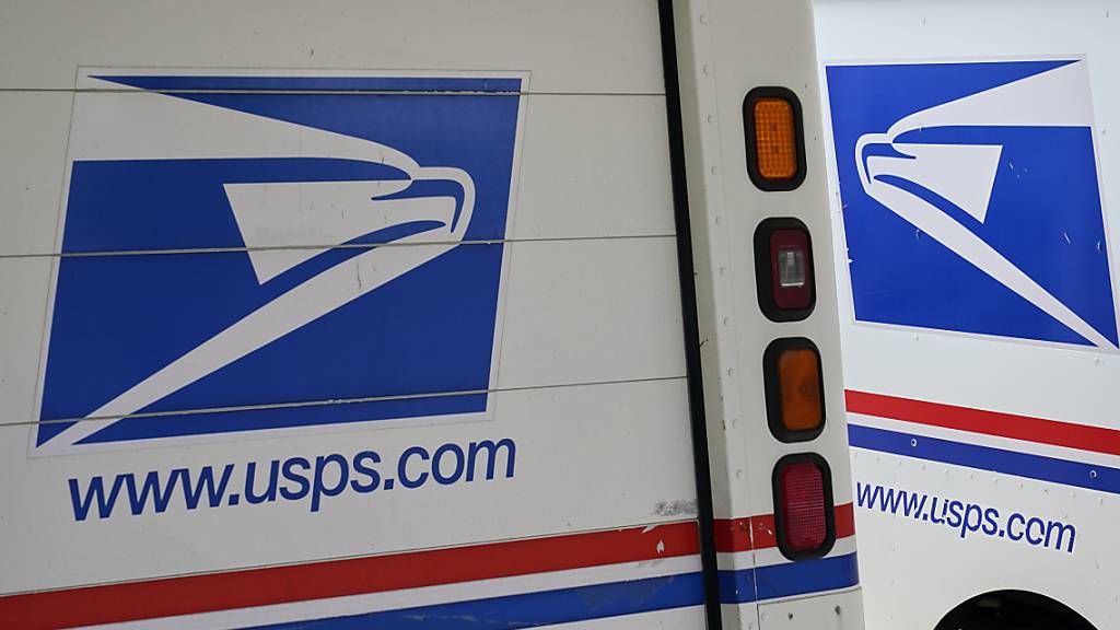 Postzustellfahrzeuge sind vor einem Postamt geparkt. Foto: Nati Harnik/AP/dpa