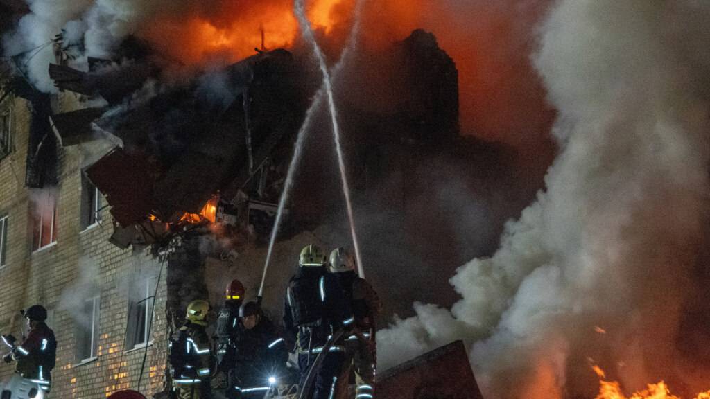 dpatopbilder - Feuerwehrleute bekämpfen einen Brand in einem Mehrfamilienhaus nach einem russischen Raketenangriff in Charkiw, Ukraine. Foto: Andrii Marienko/AP/dpa