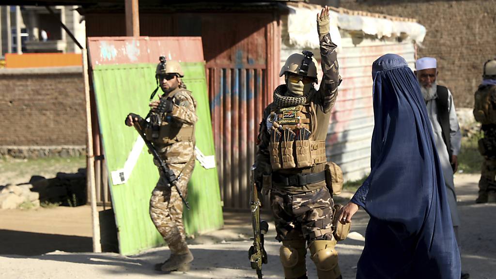 Sicherheitskräfte arbeiten am Anschlagsort nördlich der Hauptstadt Kabul im Distrikt Schakar Dara. Bei dem Anschlag sind mindestens zwölf Menschen getötet worden. Foto: Rahmat Gul/AP/dpa
