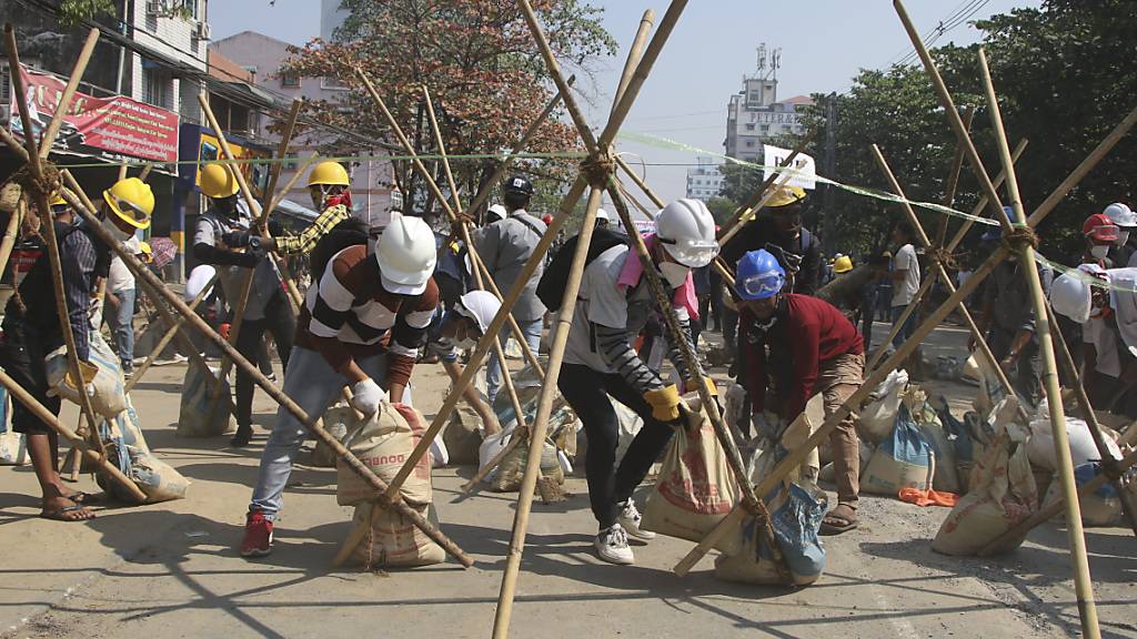 Demonstranten errichten während eines Protestes gegen den Militärputsch eine Barrikade. Foto: Str/AP/dpa