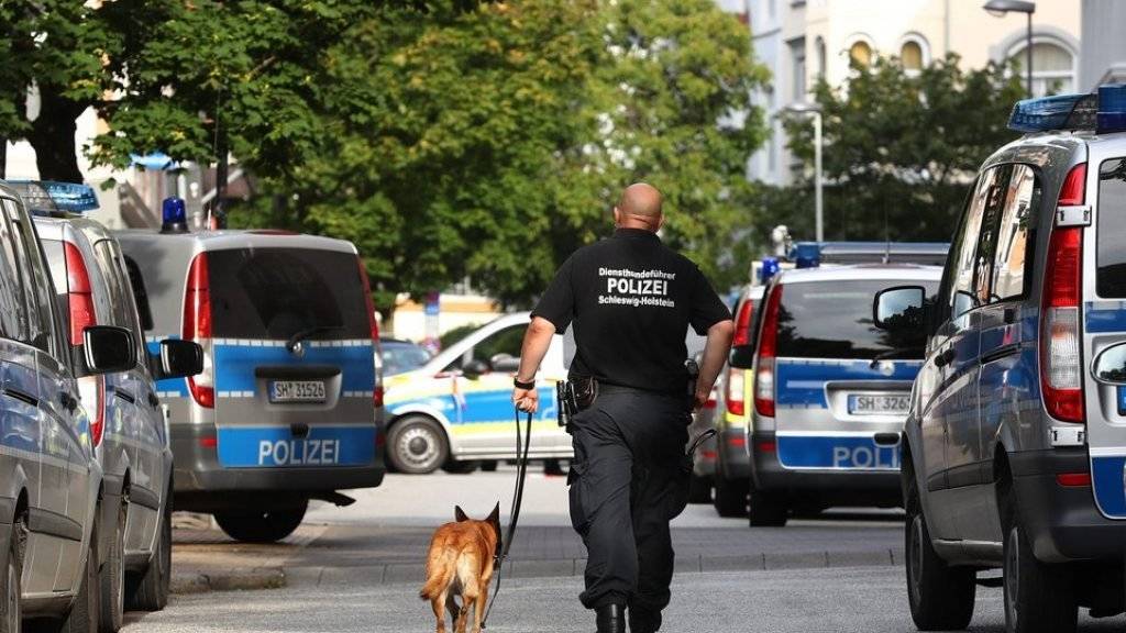 Polizist mit Spürhund am Freitag in Kiel nahe einer vom Erpresser bedrohten Schule.