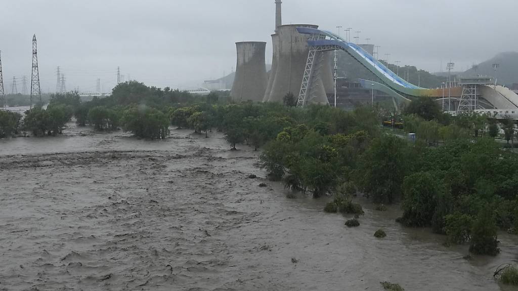 Ein angeschwollener Yongding-Fluss überflutet die Ufer in der Nähe des Shougang-Parks. Foto: Andy Wong/AP/dpa