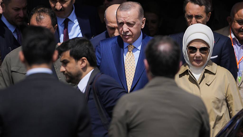 dpatopbilder - Der türkische Staatspräsident und Vorsitzende der AKP-Partei, Recep Tayyip Erdogan, Mitte, verlässt nach der Stimmabgabe für die Kommunalwahlen ein Wahllokal. Foto: Khalil Hamra/AP
