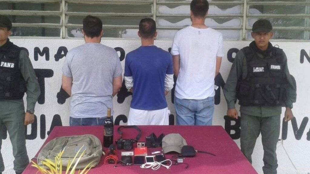 Mit dem Rücken zur Kamera: die drei Journalisten mit ihren Aufnahmegeräten nach ihrer Festnahme im Gefängnis Tocorón. (Archivbild)
