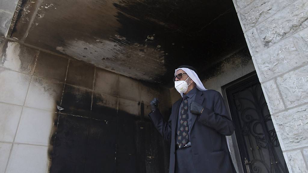 Ein Palästinenser mit Mundschutz inspiziert die verbrannten Mauern der Moschee. Foto: Nasser Nasser/AP/dpa
