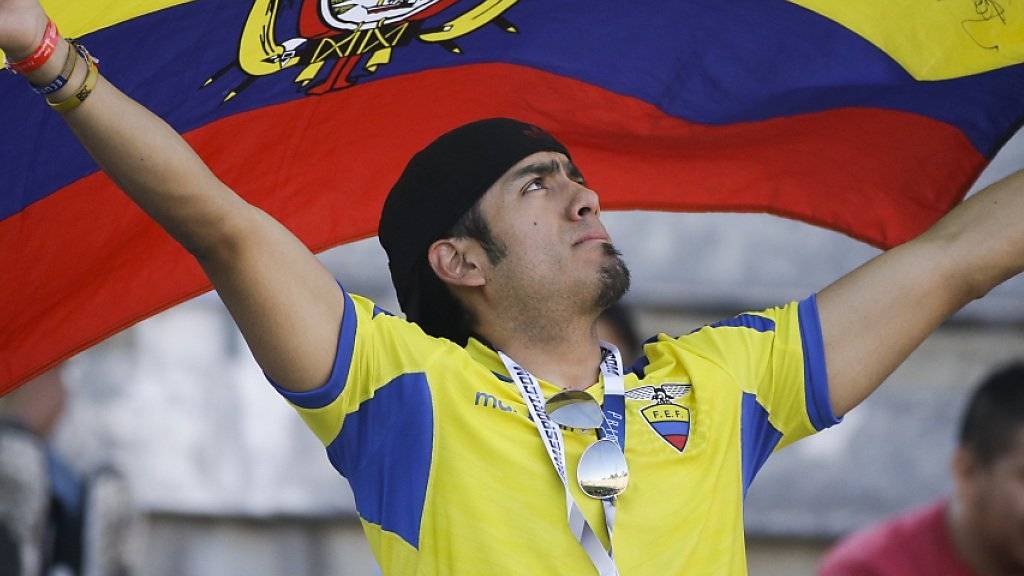 Ein Fan hält stolz die Flagge Ecuadors in die Höhe