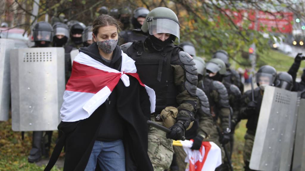 In Minsk verhaftet ein Polizist eine Demonstrantin.