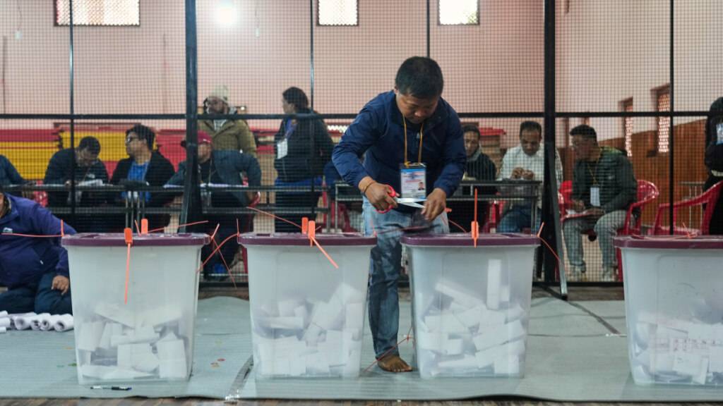 Ein Wahlhelfer öffnet eine Wahlurne für die Stimmenauszählung für die Parlamentswahlen  in einem Auszählungszentrum. Foto: Niranjan Shrestha/AP/dpa