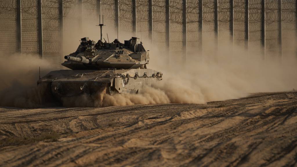 Israelische Soldaten bewegen sich mit einem Panzer entlang der Grenze zwischen Israel und Gaza, gesehen vom Süden Israels aus. Foto: Leo Correa/AP/dpa