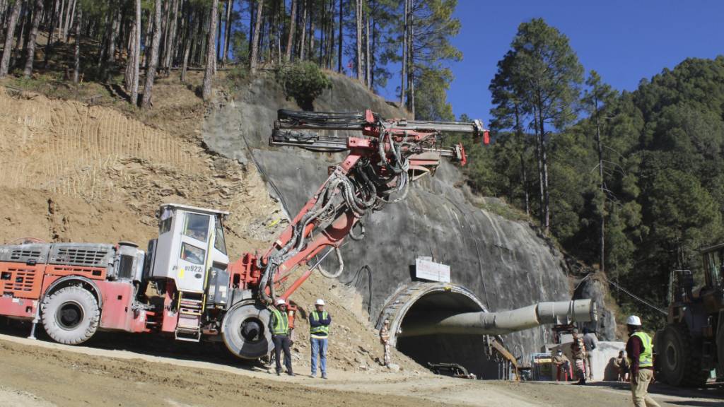 Maschinen und Arbeiter sind am Eingang eines im Bau befindlichen Straßentunnels zu sehen, der eingestürzt ist und 40 Arbeiter im nordindischen Bundesstaat Uttarakhand eingeschlossen hat. Foto: Uncredited/AP