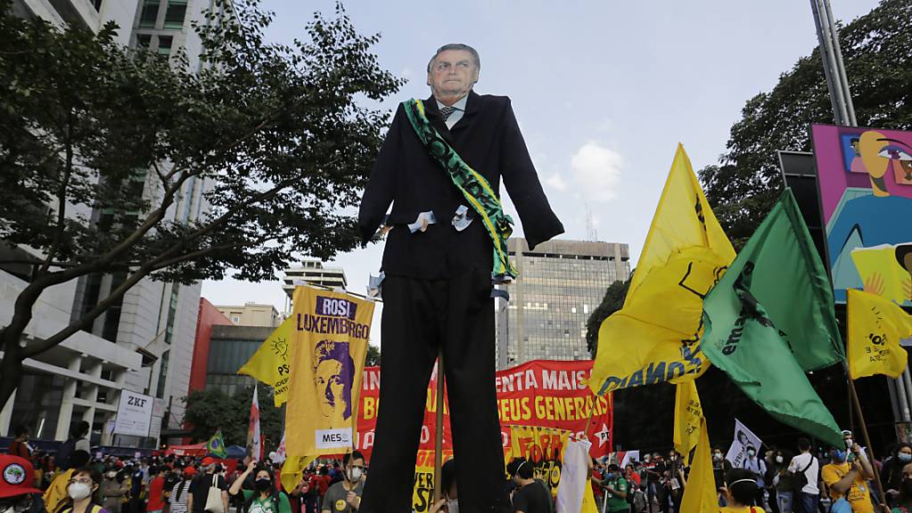 Menschen, die an einem Marsch auf der Avenida Paulista teilnehmen, um den Rücktritt des brasilianischen Präsidenten Jair Bolsonaro zu fordern, tragen einen riesigen Ausschnitt von Bolsonaro.